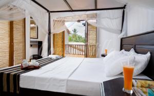 a bedroom with a bed with a drink on a table at Conch Villa in Tangalle
