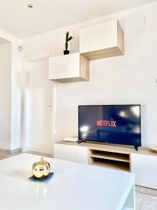 a living room with a tv and a table at Appartement devant la plage in Roses