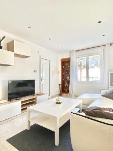 a white living room with a couch and a table at Appartement devant la plage in Roses