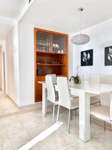 a dining room with a white table and white chairs at Appartement devant la plage in Roses