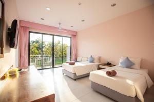 a bedroom with two beds and a large window at Xanadu Beach Resort in Ko Larn