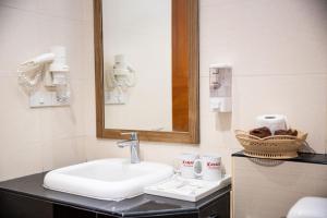a white sink sitting under a mirror in a bathroom at Xanadu Beach Resort in Ko Larn