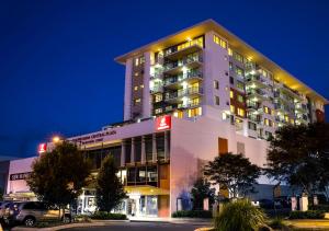 Toowoomba Central Plaza Apartment Hotel Official في توومبا: مبنى كبير فيه فندق بالليل