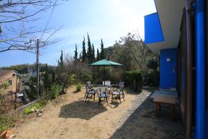 a table and chairs with an umbrella in a yard at Tiz wan 洲本 in Sumoto