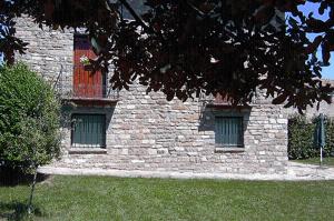 a brick building with two windows in a yard at Casa Campo in Abay