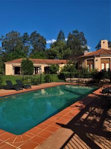a swimming pool in front of a house at Estate Tuscany in Pokolbin