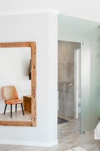espejo en una habitación con silla y baño en Stunning House in Bo Kaap en Ciudad del Cabo