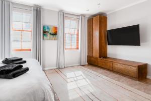 a bedroom with a bed and a flat screen tv at Stunning House in Bo Kaap in Cape Town