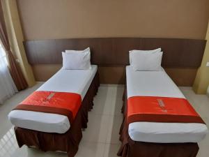 Hotel Bumi Makmur Indah في باندونغ: سريرين يجلسون بجانب بعض في غرفة