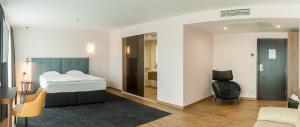 um quarto com uma cama, uma cadeira e um espelho em Amiral Hotel (former Best Western Park Hotel) em Varna City