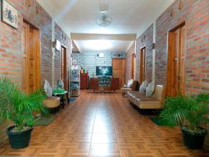 una hall con divani e TV in un muro di mattoni di Ngampilan Backpacker Hostel a Yogyakarta