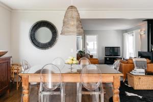 a dining room table with chairs and a mirror at Cottage 103 in Waikanae