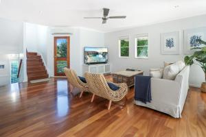 a living room with a couch and a tv at Privacy by the river, Noosaville in Noosaville