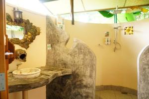 a bathroom with a stone sink and a mirror at Eco-Logic, Resort for Charity in Phato