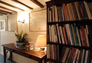 una estantería llena de libros junto a una mesa con una lámpara en Porch House, en Northallerton
