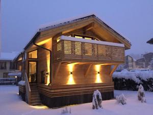 una casita en la nieve con luces encendidas en Chalet des Sapins, en Chamonix-Mont-Blanc