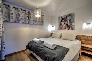 1 dormitorio con 1 cama con 2 toallas en Chalet des Sapins, en Chamonix-Mont-Blanc