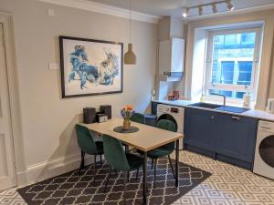 a kitchen with a table and chairs and a sink at Central Hawick spacious stylish flat with log burner in Hawick