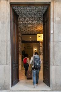 a man walking down a hallway with an open suitcase at Toc Hostel Granada in Granada