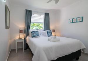 a bedroom with a large white bed and a window at Chakas Cove 99 in Ballito