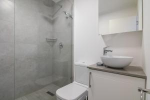 a bathroom with a toilet and a sink and a shower at Chakas Cove 99 in Ballito