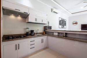 eine Küche mit weißen Schränken und einer Arbeitsplatte in der Unterkunft Villa Voyage 5 in Seminyak