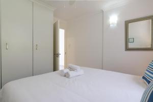 a white bed with a towel on top of it at Chakas Cove 99 in Ballito
