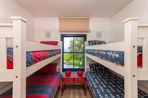 a room with three bunk beds and a window at Santorini - Pyrgos 15 in Ballito