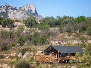 a cabin on a hill with a mountain in the background at Can Elisa Safari Tent in Tárbena