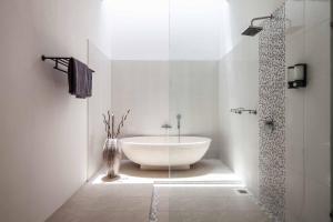 ein weißes Badezimmer mit Badewanne und Dusche in der Unterkunft Villa Voyage 5 in Seminyak + 20 Fotos