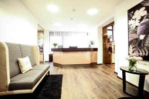 a living room with a couch and a desk at City Partner Hotel Berliner Hof in Karlsruhe