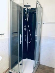 a shower with a glass door in a bathroom at Stort rymligt boende med två sovrum och pentry i lantlig miljö in Höllviken