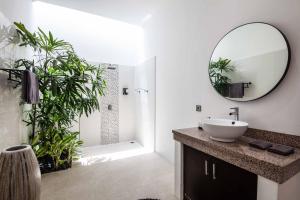 ein Badezimmer mit Waschbecken, Dusche und Spiegel in der Unterkunft Villa Voyage 5 in Seminyak