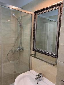 uma casa de banho com um lavatório e um chuveiro com um espelho. em Best West Sveta Nedelja em Sveta Nedjelja
