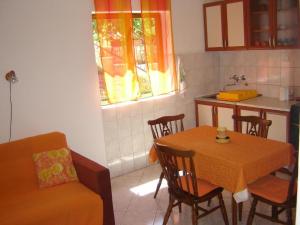 - une cuisine avec une table, des chaises et un évier dans l'établissement Apartments Grgorinić - Ground Floor, à Pula