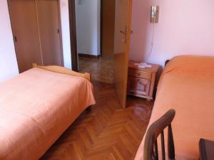 1 dormitorio con 2 camas y suelo de madera en Apartments Grgorinić 3 bedrooms, en Pula