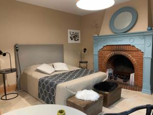 a bedroom with a bed and a fireplace at EN VILLE À LA CAMPAGNE in Louhans