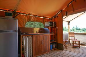 an orange tent with a sink and a refrigerator at Cabane Ayana in Saint-Maximin-la-Sainte-Baume