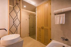 a white bathroom with a sink and a shower at Aurico Kata Resort & Spa - SHA Extra Plus in Kata Beach