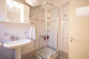 a bathroom with a sink and a glass shower at Andrew's Old Town Apartment in Corfu +10 photos