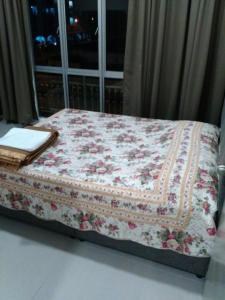 una cama con un edredón delante de una ventana en Barrington Square 2 Rooms Apartment at Golden Hill Night Market en Brinchang