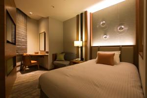 una camera d'albergo con letto e sedia di Highland Resort Hotel & Spa a Fujiyoshida
