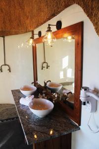 Baño con 2 lavabos y espejo en Desert Hills Lodge, en Sesriem