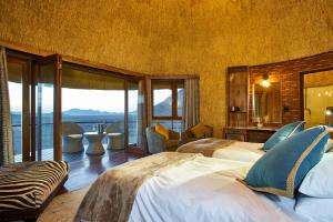 1 dormitorio con 2 camas y vistas al océano en Desert Hills Lodge, en Sesriem