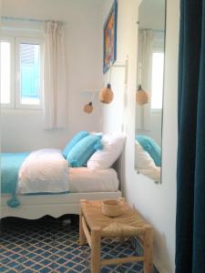 a bedroom with a bed and a mirror at Hôtel Emeraude Essaouira in Essaouira