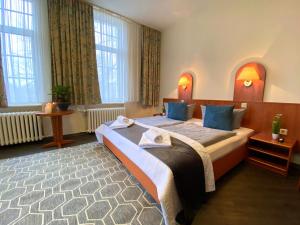 Postel nebo postele na pokoji v ubytování REGIOHOTEL Quedlinburger Hof Quedlinburg + 32 fotografií