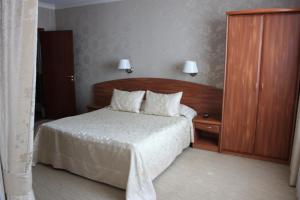 - une chambre avec un lit doté d'une tête de lit en bois dans l'établissement Kristall Hotel, à Dmitrov