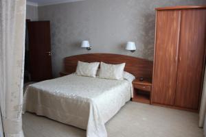 um quarto com uma cama com uma cabeceira de madeira em Kristall Hotel em Dmitrov