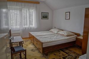 a bedroom with a bed and a table and a chair at APARTMA JANŠA in Bled