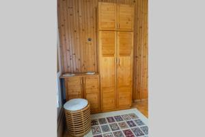 a corner of a room with wooden cabinets and a stool at APARTMA JANŠA in Bled